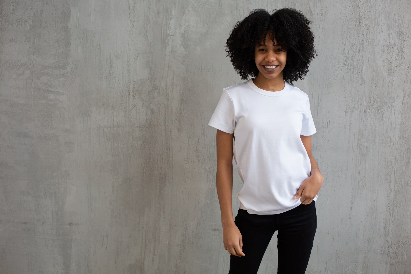 Smiling black woman in white t shirt and pants